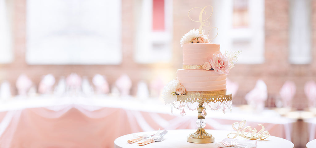 pretty pink tiered cake on gold chandelier cake stand